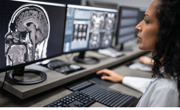 Female radiologist looking at scan after MRI in hospital laboratory  Young female doctor working on computer for medical exam in clinic 