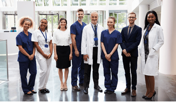 Portrait Of Medical Staff Standing In Lobby Of Hospital