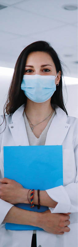 Portrait of a female doctor in the CT scanner room wearing a protective face mask 